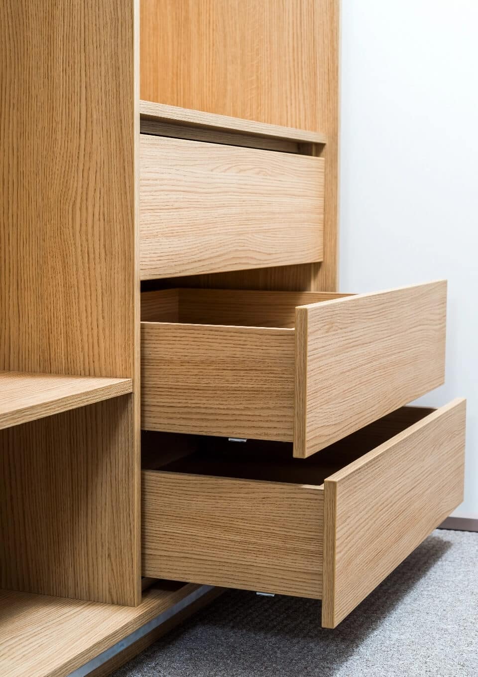 Commode en chêne clair avec tiroirs ouverts révélant le grain naturel du bois massif et son design minimaliste.